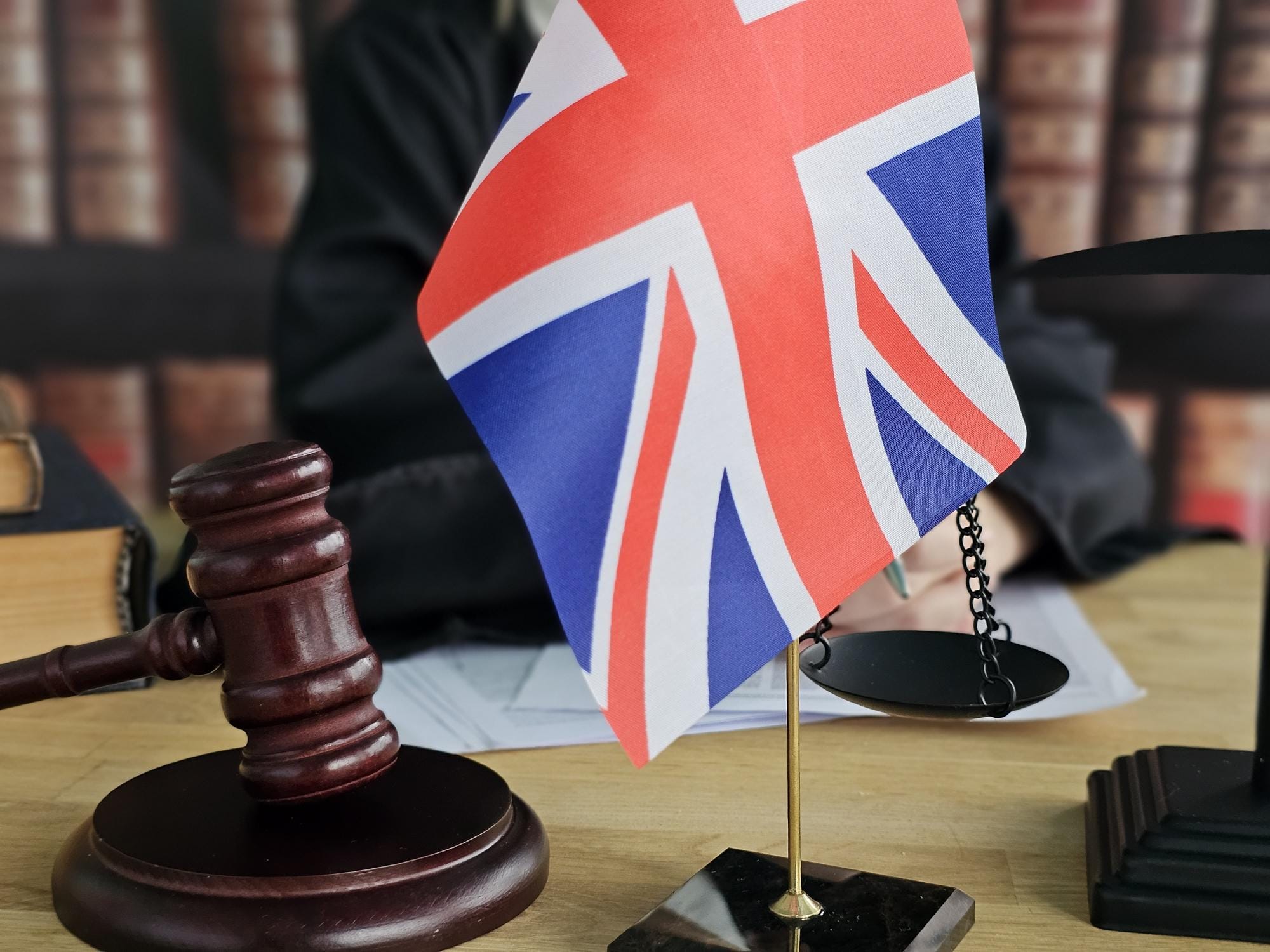 Professional UK law office desk with legal documents and justice scales