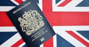 Blue British passport lying on a Union Jack flag