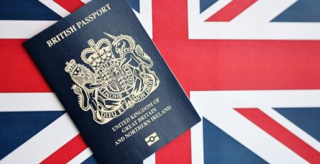 Blue British passport lying on a Union Jack flag