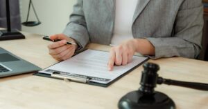 Solicitor reviewing an employment contract on a clipboard, with a gavel on the desk